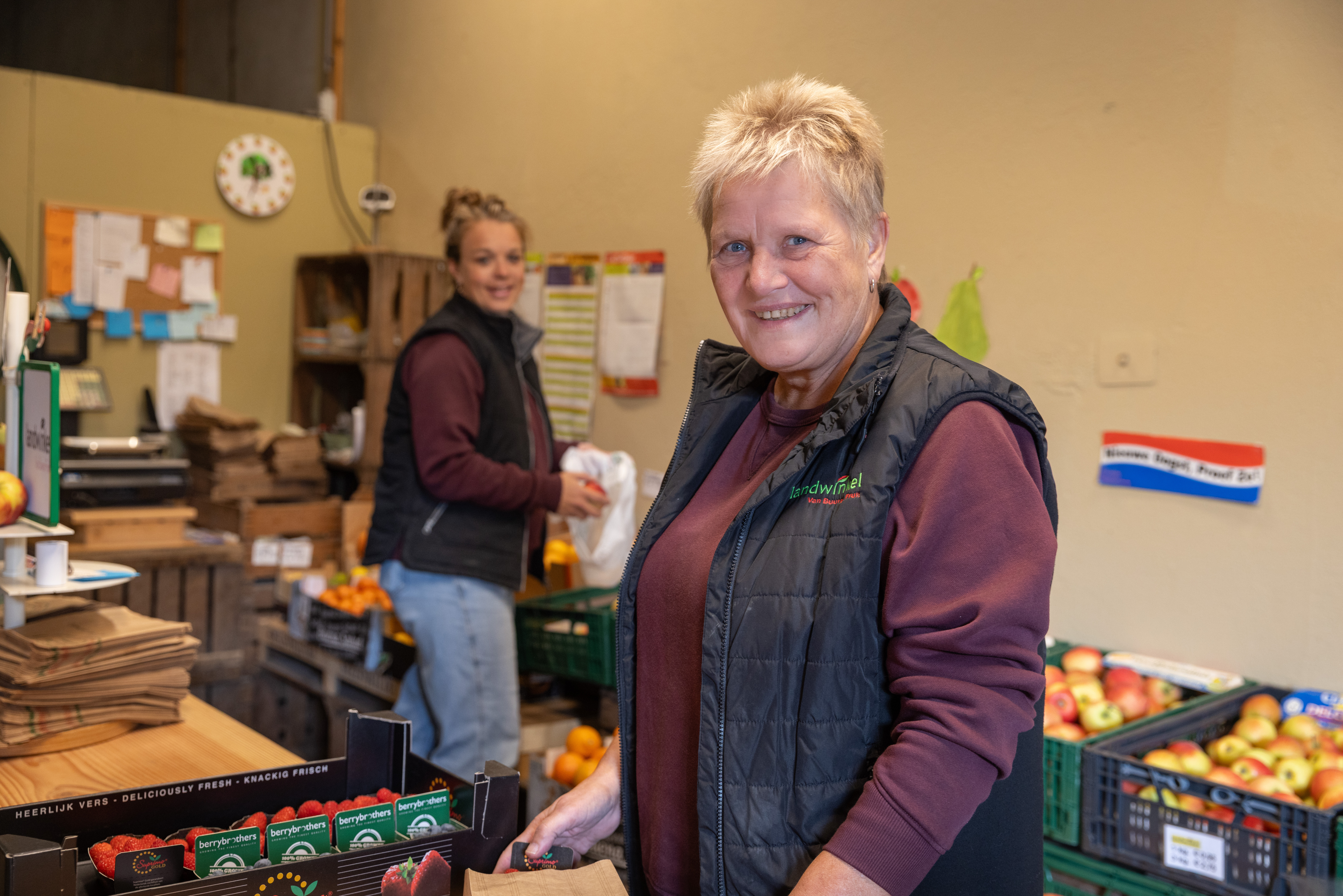 Twee vrouwen in een winkel met kratten met appels