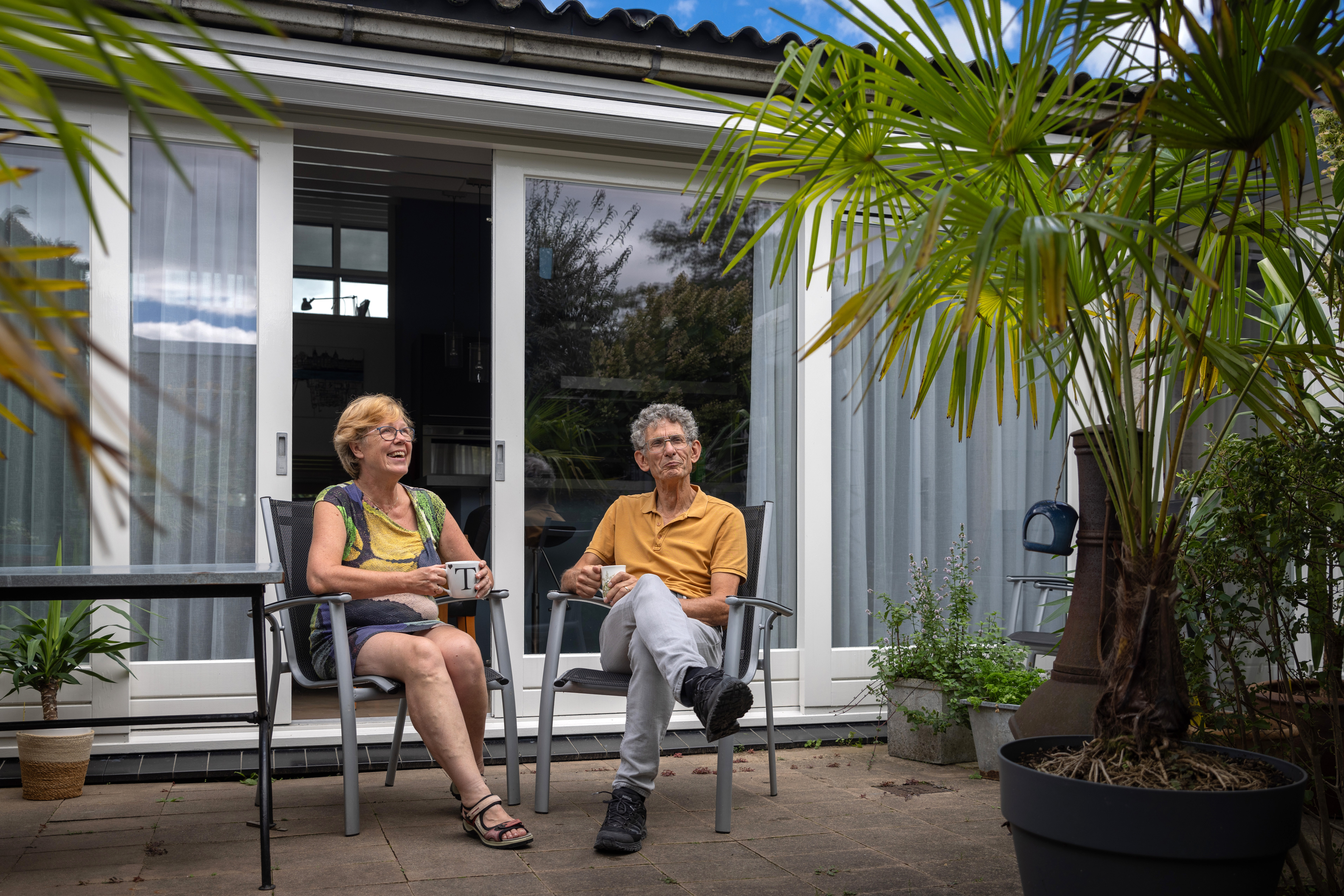 Foto van Marja en Ruud zittend op stoelen in hun tuin
