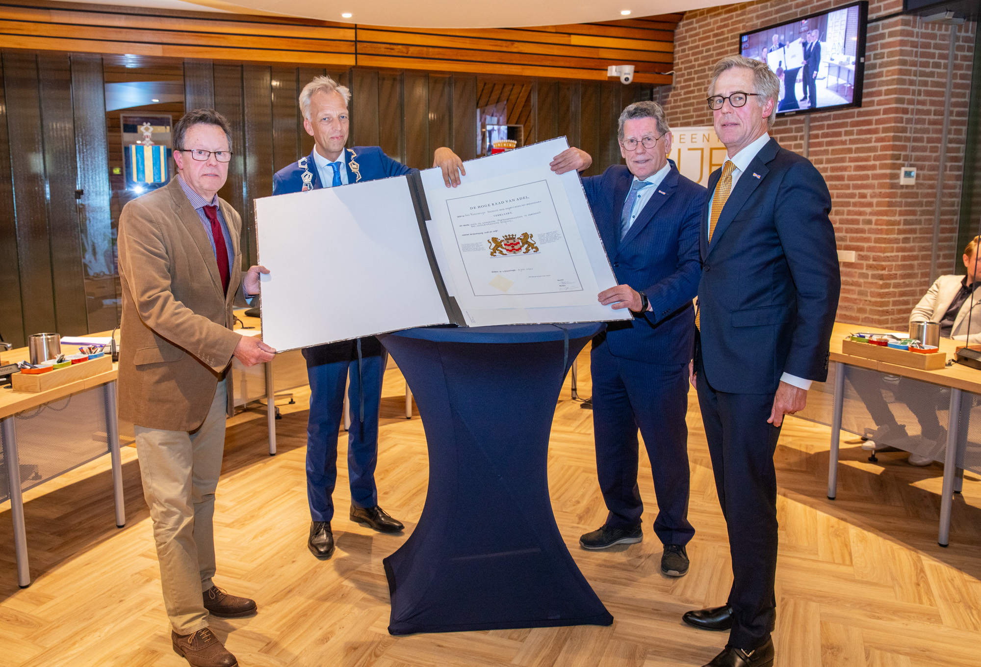 Burgemeester Fröhlich, raadslid Dick den Hertog nemen het wapendiploma van de gemeente Vijfheerenlanden in ontvangst van Marc Scheidius en Jos van den Borne van de Hoge Raad van Adel.